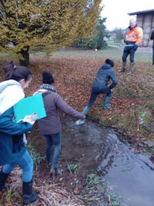 étudiants enjambant en sautant un cour d'eau