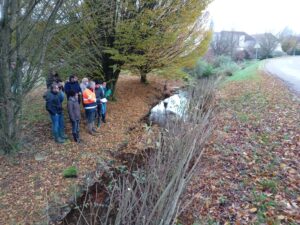 groupe d'étudiant avec un professionnel au bord d'un cour d'eau