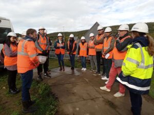 groupe d'étudiant en exploration terrain avec des professionnels équipés de casques de chantier